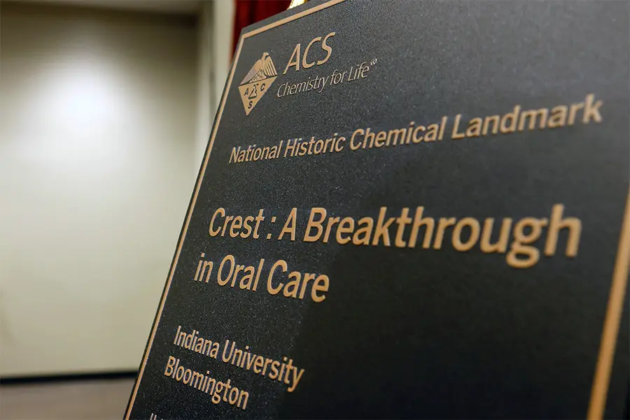 A plaque states these words. ACS, Chemistry for Life. National Historic Landmark. Crest: a Breakthrough in Oral Care. Indiana University Bloomington.