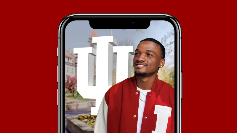 An iPhone shows a photo of a man standing in front of the IU Trident.