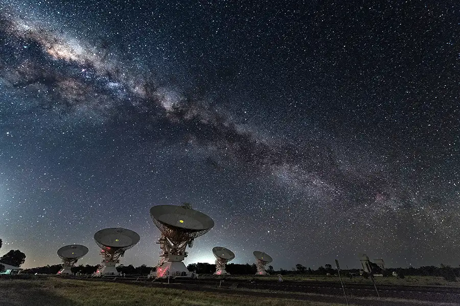 Field of satellite dishes under night sky showing the Milky Way