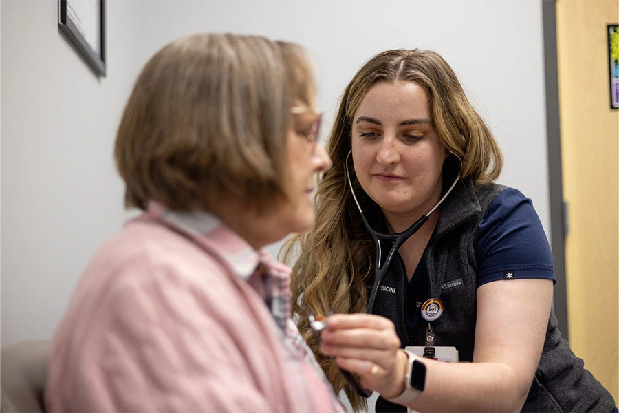 An IU nurse listens to the heartbeat of a patient with a stethoscope.