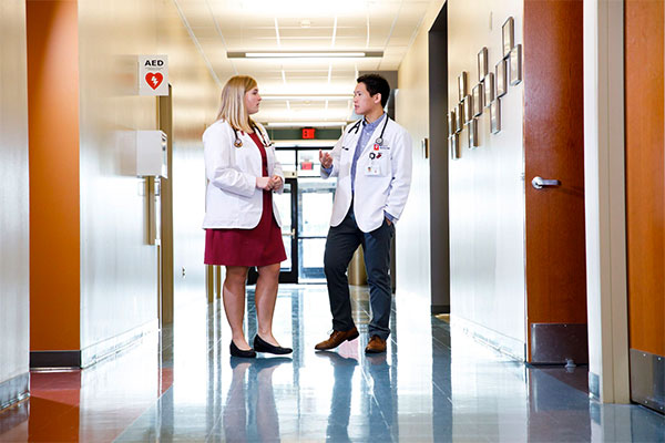 Two IU medical students talking in the hallway of a doctor's office