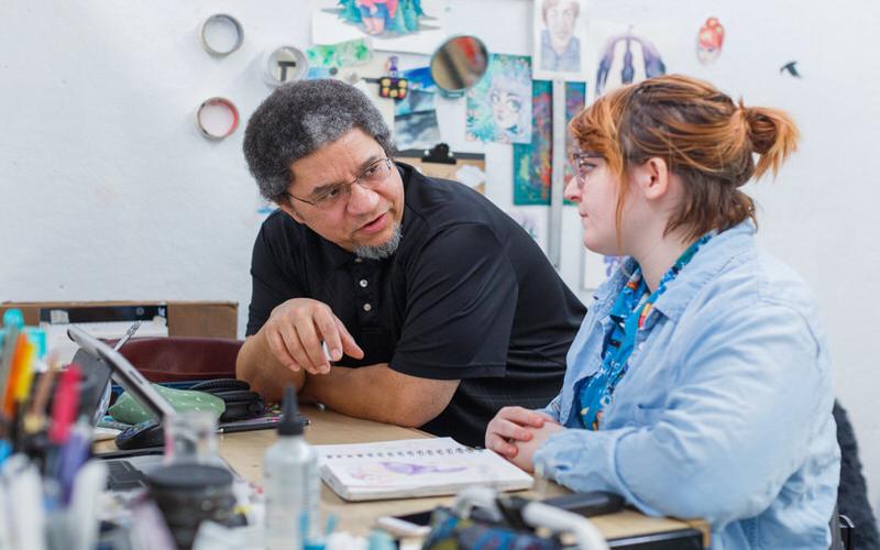 IU professor works with a student in class.