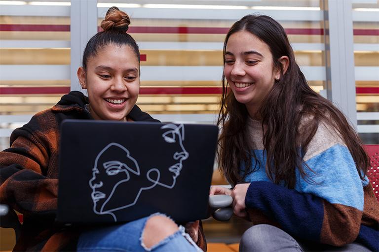 Two female students preparing for at JagStart presentation.