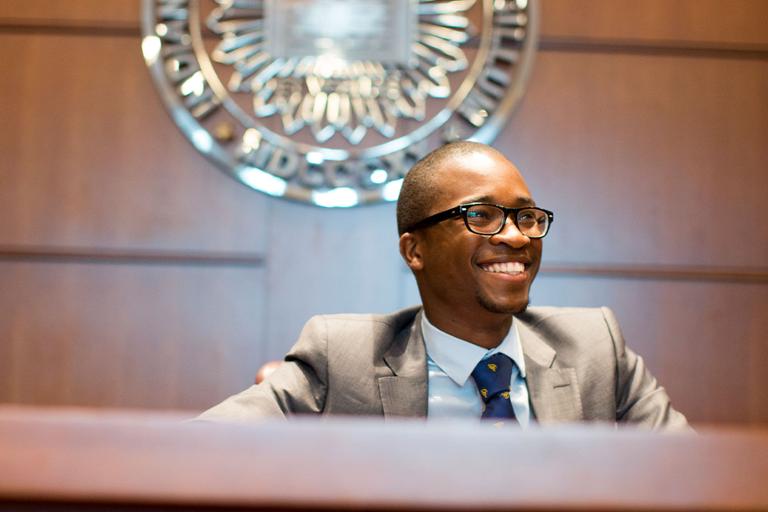 Man sitting at a judge's bench.