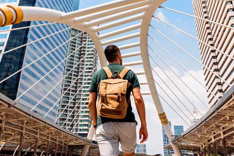 Man walking under a bridge.