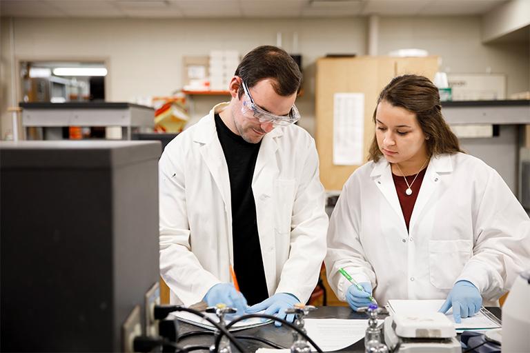 Two undergraduate students doing research in a lab.