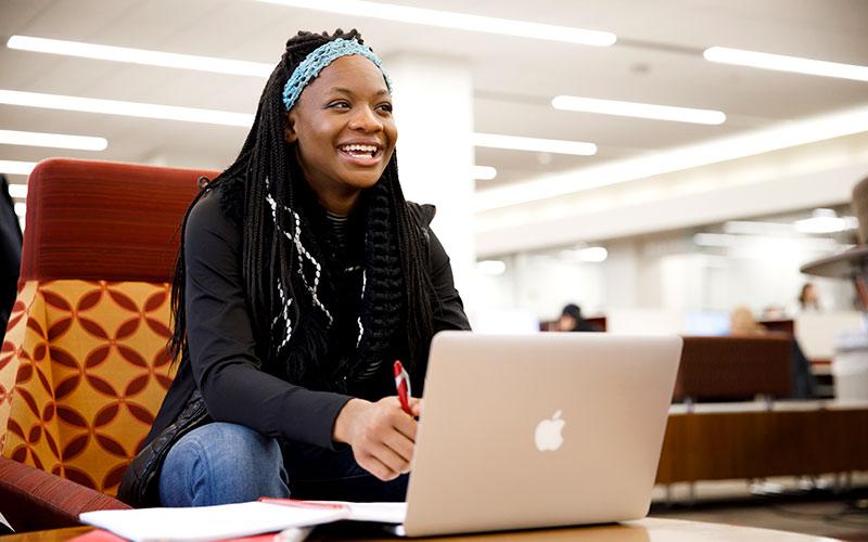 A female student sits at her computer.