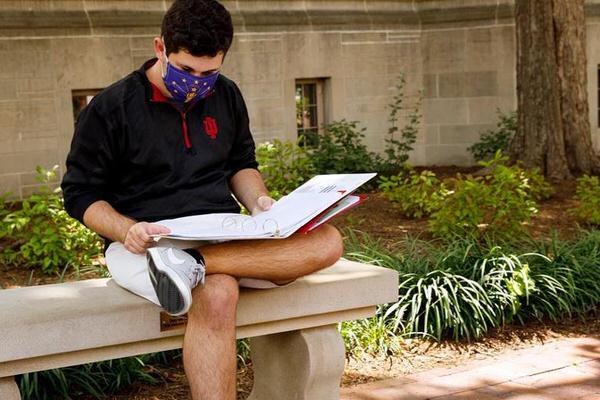IU Bloomington student reading orientation materials on campus.