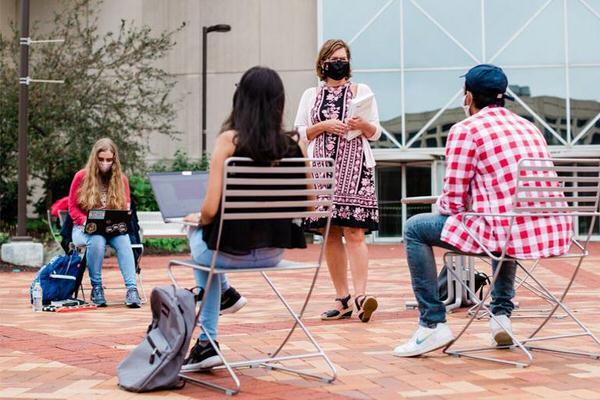 Female professor leading class outside on the IUPUI campus.