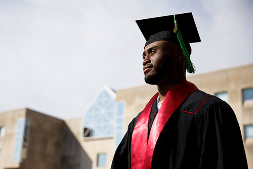 IU student during commencement, wearing a cap and gown