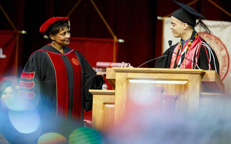 IU students receiving diploma at graduation.