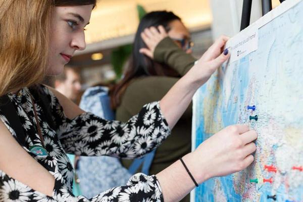 IU student placing pushpins on a world map.