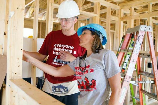 A teacher instructing a student in a house that is under construction.