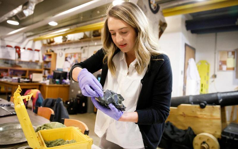IU student doing looking at an artifact.