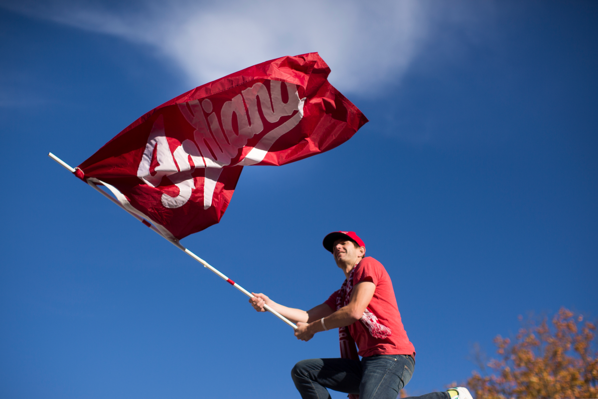 An IU Student waves a red Indiana flag