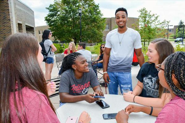 Group of students eating lunch outdoors on the IU East campus.