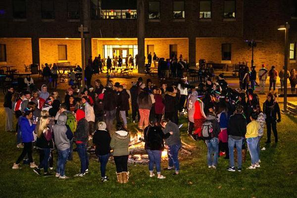 Large group of students in front of bonfire on the IU East campus.