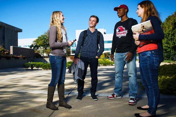 Group of undergraduate students having a discussion outside.